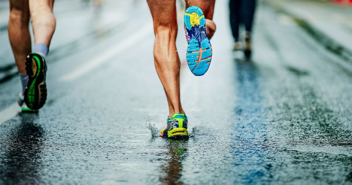 runners running on wet pavement