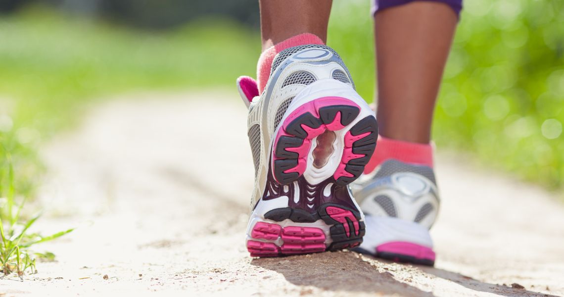 close up of pink and white tennis shoes while person is walking