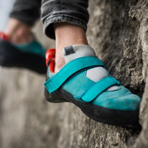 closeup of rock climber's shoes while climbing